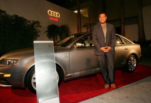 Hajna O. Moss's ex-husband Laurence Fishburne posing for photo in front of car